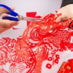 Person cutting red paper. 